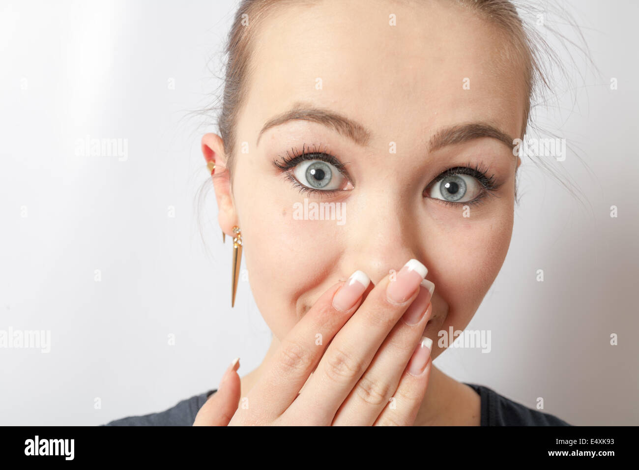 young girl covering his mouth with his hand Stock Photo