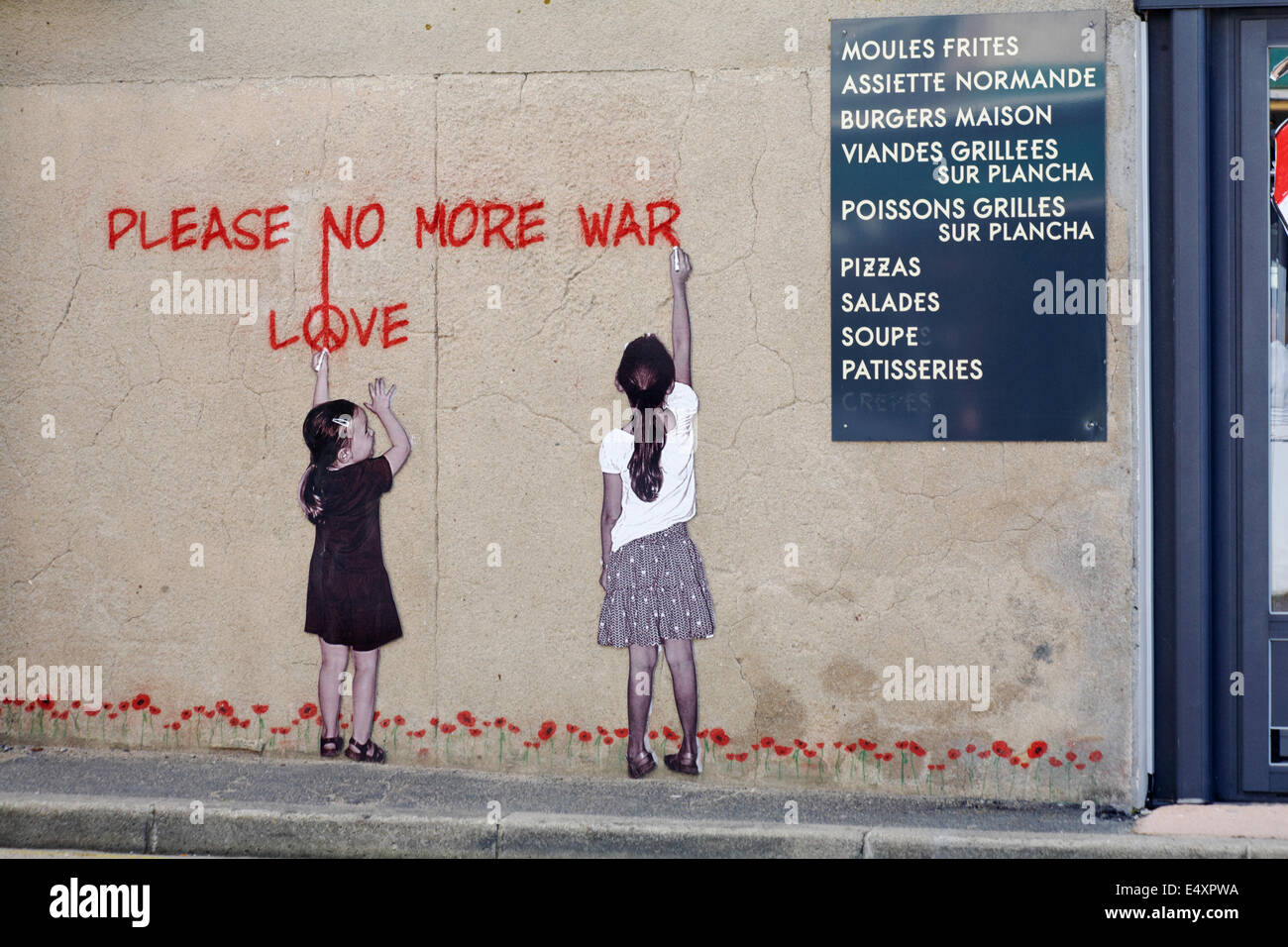 painting of two girls writing Please no more war Love on wall in Arromanches Normandy France in July Stock Photo