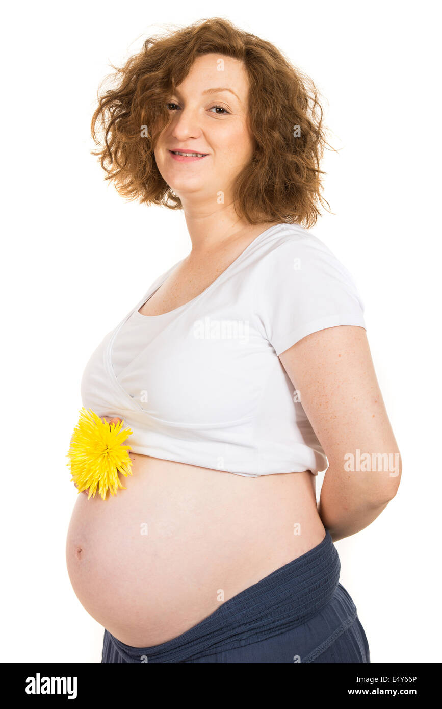 Pregnant woman holding yellow flower on her tummy isolated on white background Stock Photo