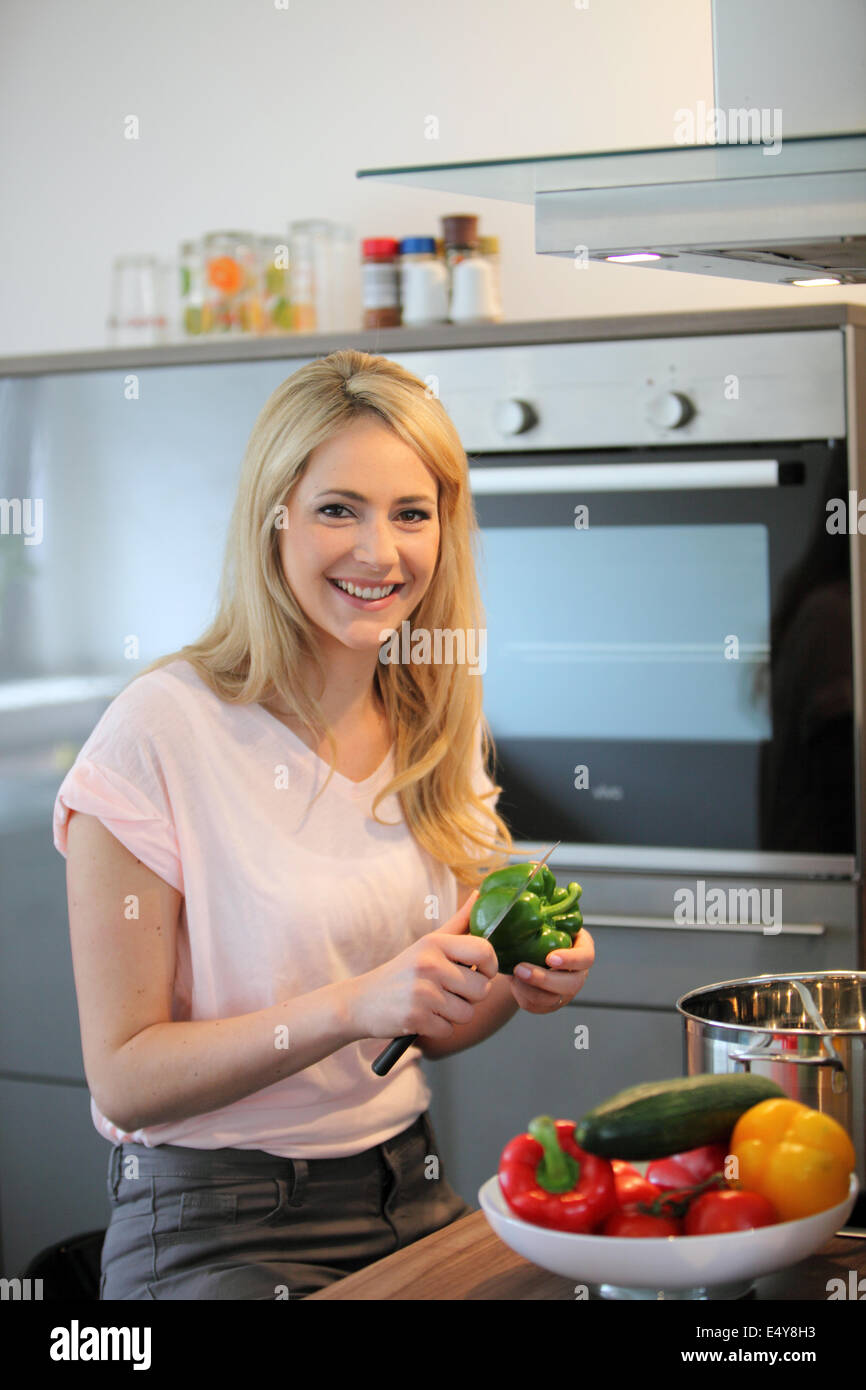 Happy woman cooking a meal in the kitchen Stock Photo