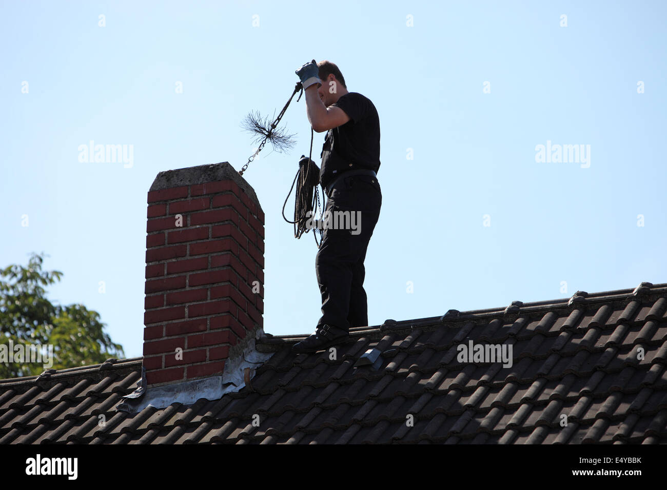 Chimney sweep inserting a brush Stock Photo