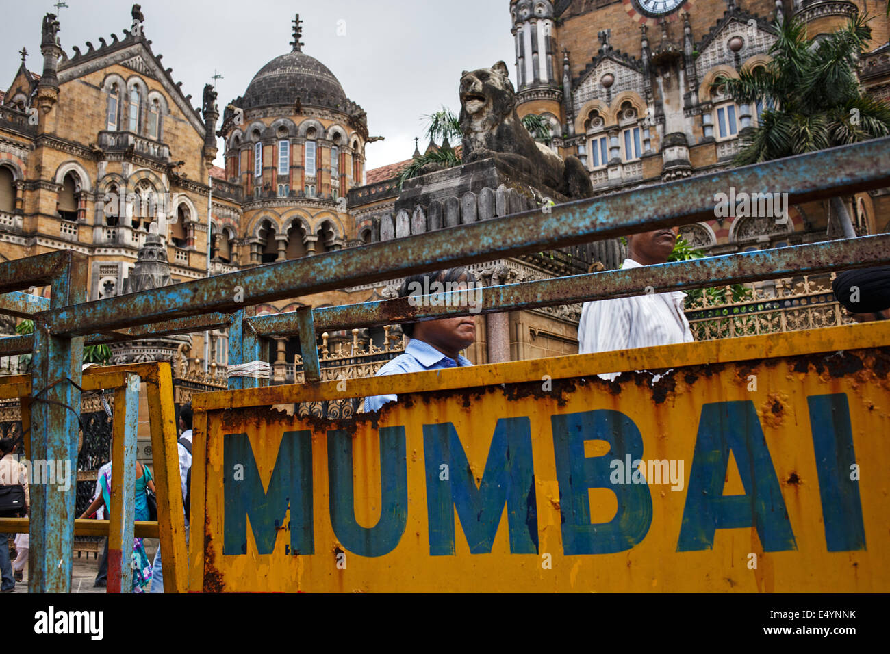 People walk in front of Chhatrapati Shivaji Terminus (CST)  (Victoria Terminus) (VT) railway train station, South Mumbai, India Stock Photo