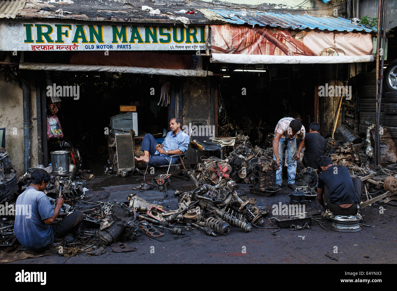 Workers in a car breaking workshop in Chor Bazaar area in Mumbai, India. Stock Photo