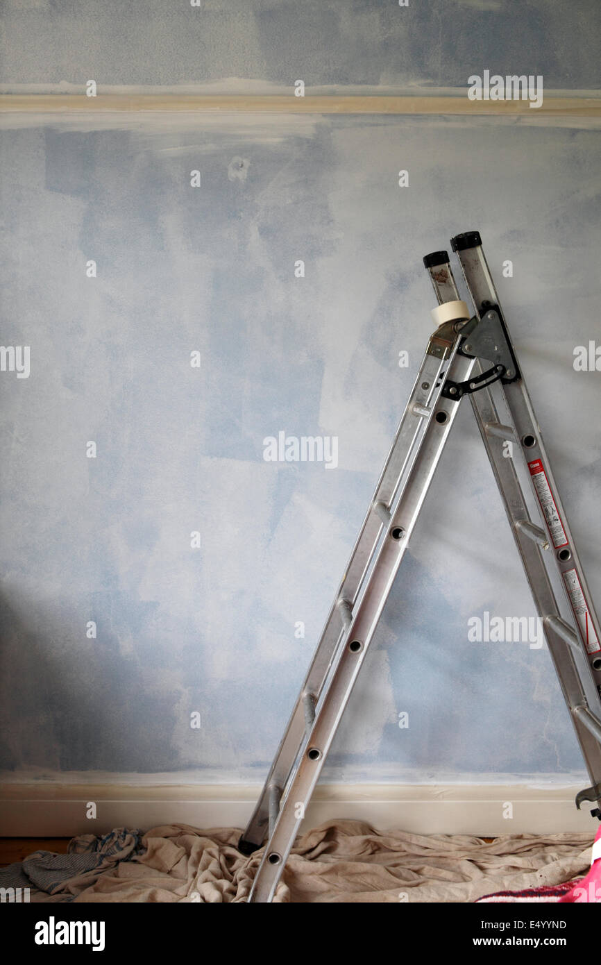 stepladder against a wall that is being decorated Stock Photo