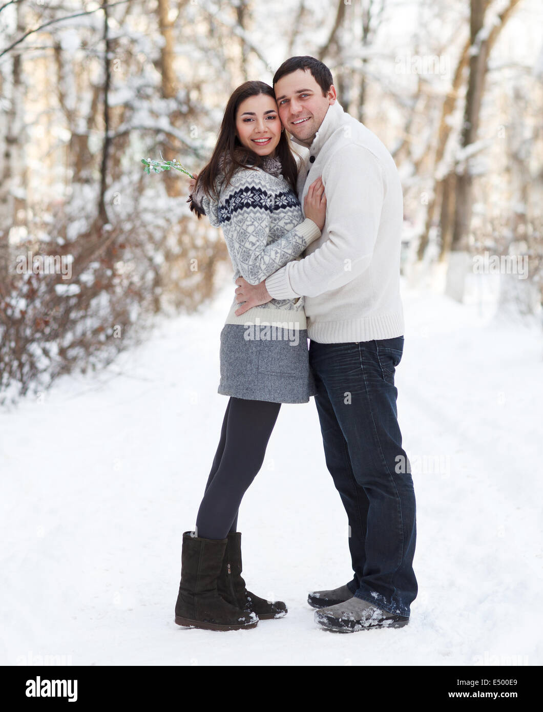 Happy young couple in the winter park Stock Photo - Alamy