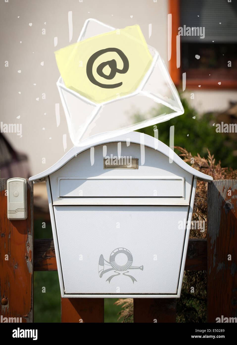 Envelope with email sign dropping into mailbox Stock Photo Alamy