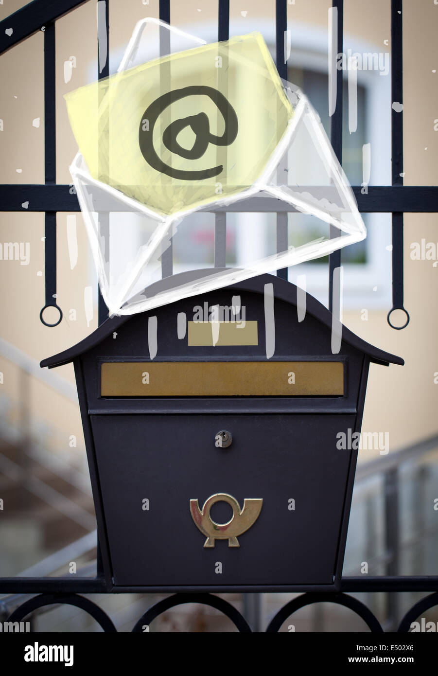 Envelope with email sign dropping into mailbox Stock Photo Alamy