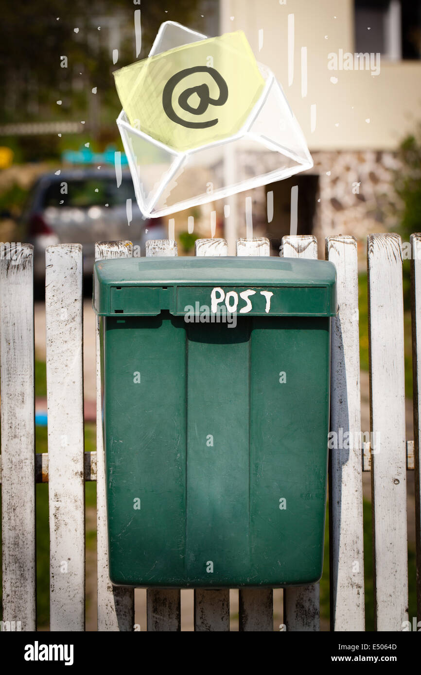 Envelope with email sign dropping into mailbox Stock Photo Alamy