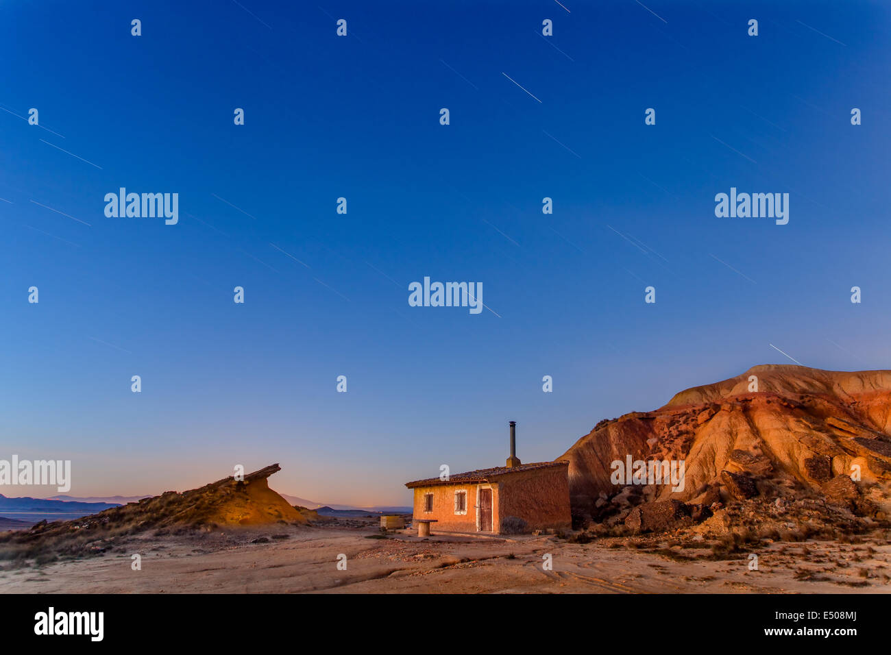 Star trail over a small house at Bardenas Reales Stock Photo
