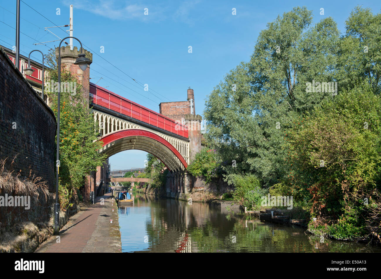 The Castlefield Urban Heritage Park and historic inner city canal conservation area including railway bridge in Manchester, UK. Stock Photo