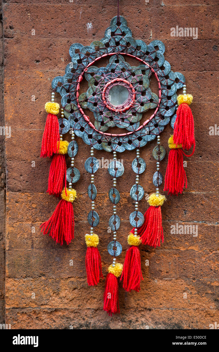 Bali, Indonesia.   Metalwork and Cloth Decoration Hanging by the Entrance to a House.  Tenganan Village. Stock Photo