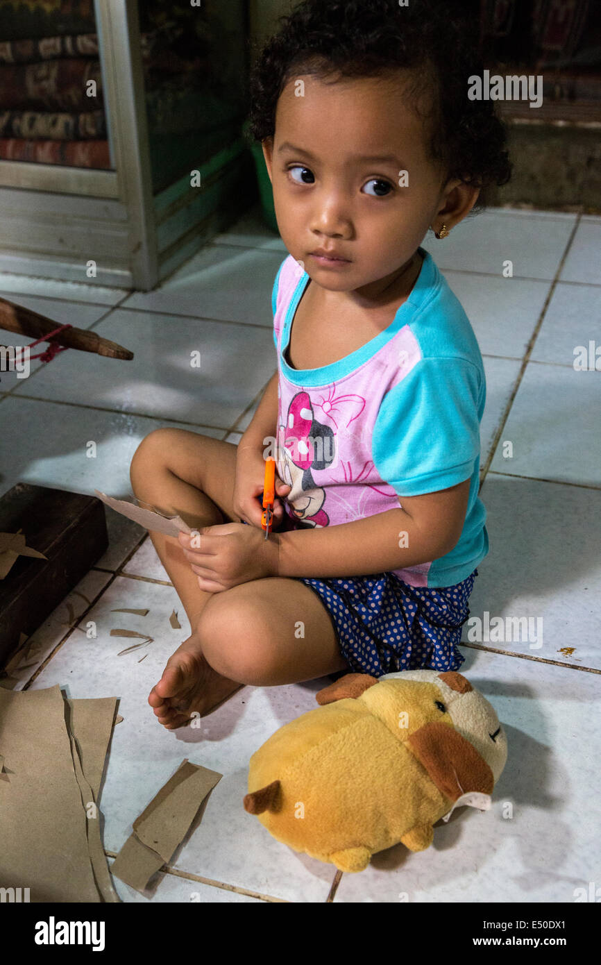 Bali, Indonesia.  Little Balinese Girl and her Stuffed Animal.  Tenganan Village. Stock Photo