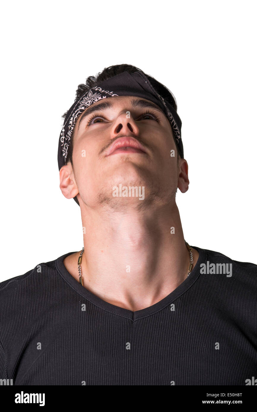 Handsome young man in a headband standing thinking with his head tilted