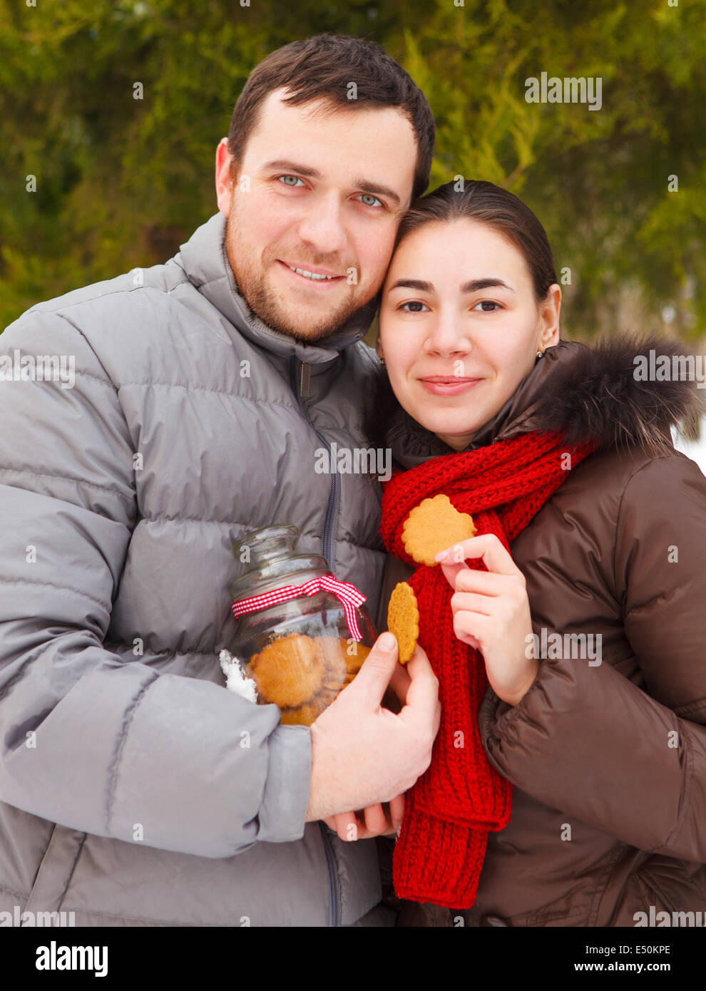 Happy young couple in the winter park Stock Photo - Alamy