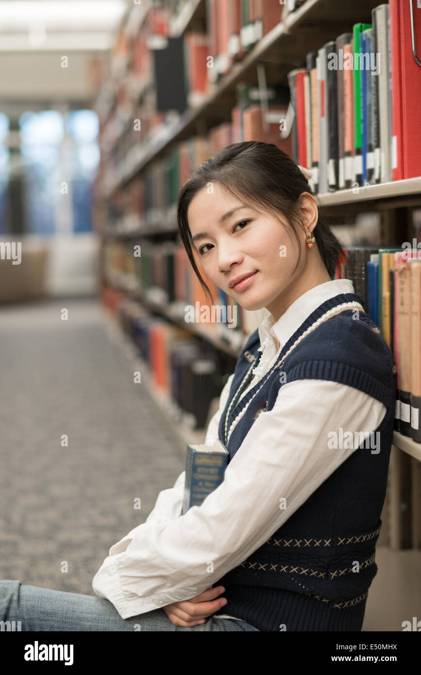 Girl sitting on the floor holding book Stock Photo - Alamy