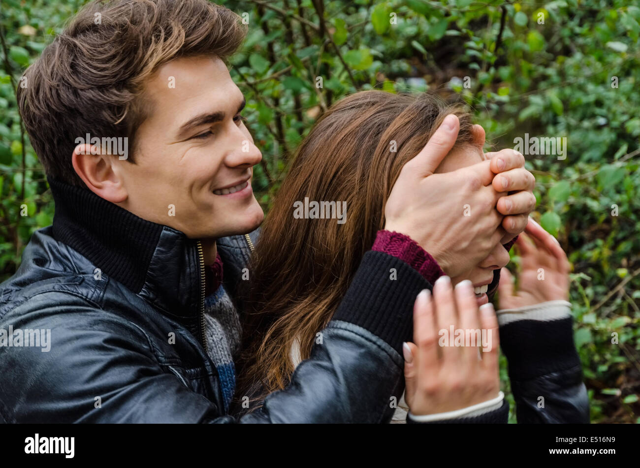 Man Covering Woman's Eyes In Park Stock Photo