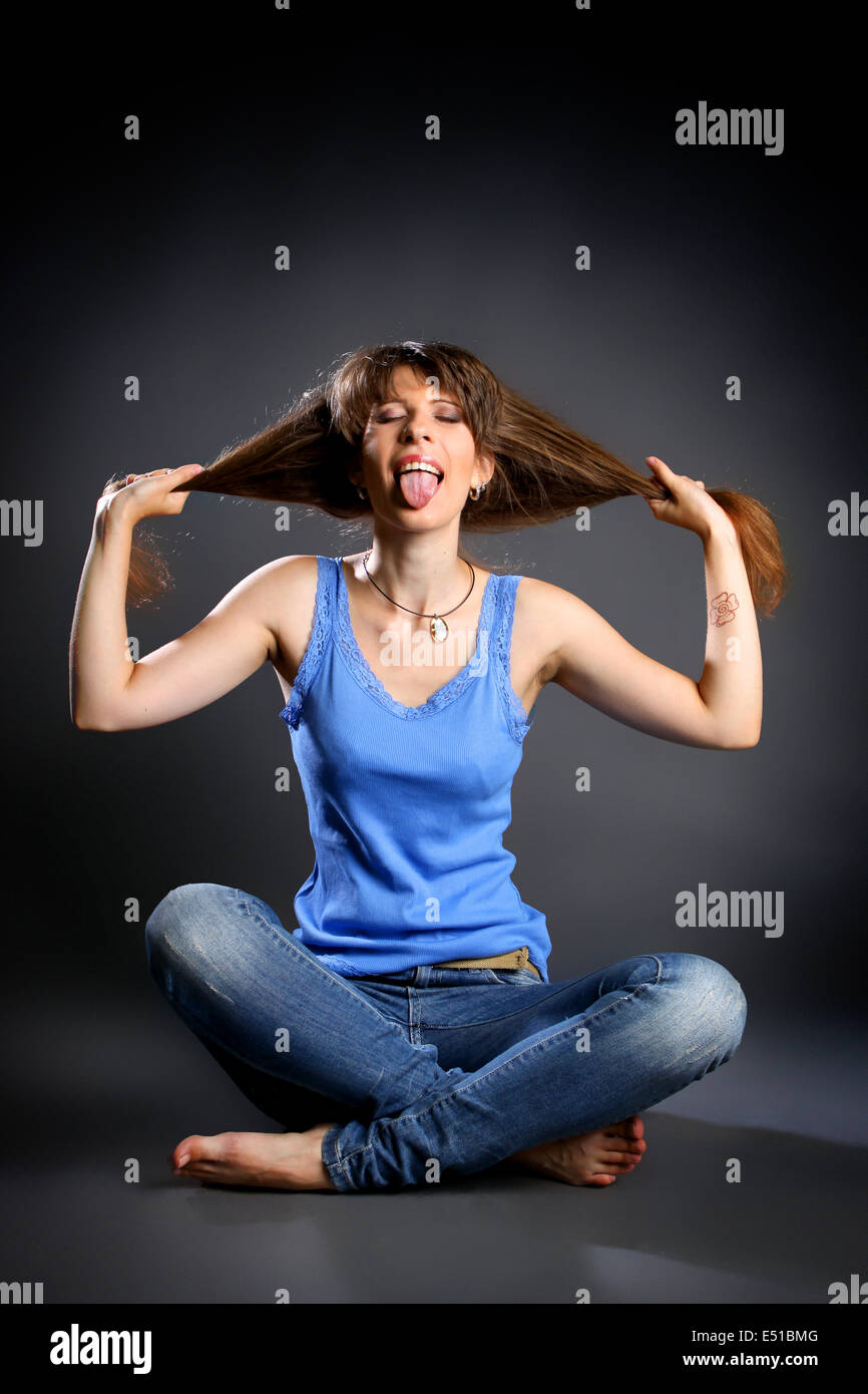 Girl sitting in the lotus position in jeans Stock Photo - Alamy