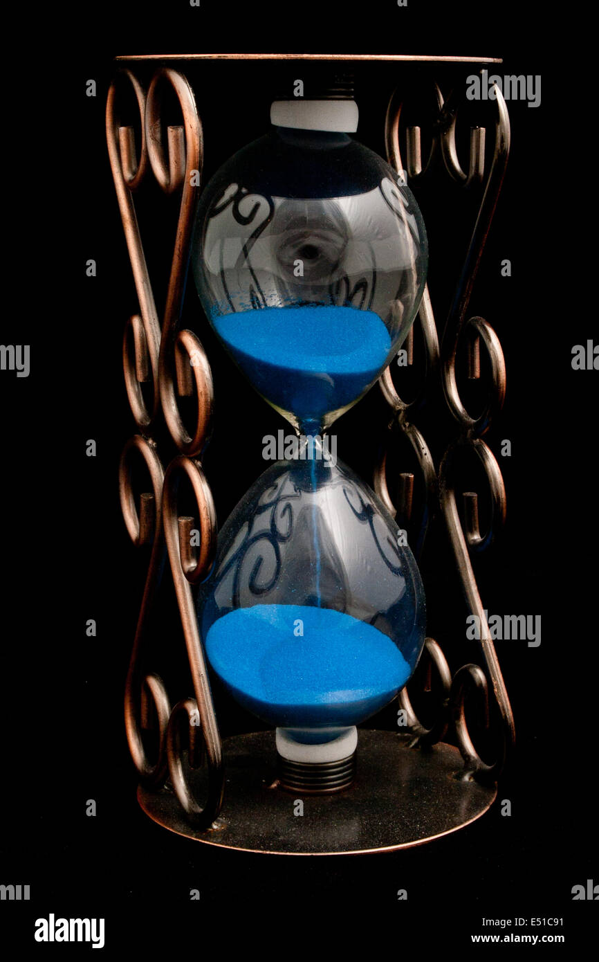 Hourglass with blue sand Stock Photo Alamy