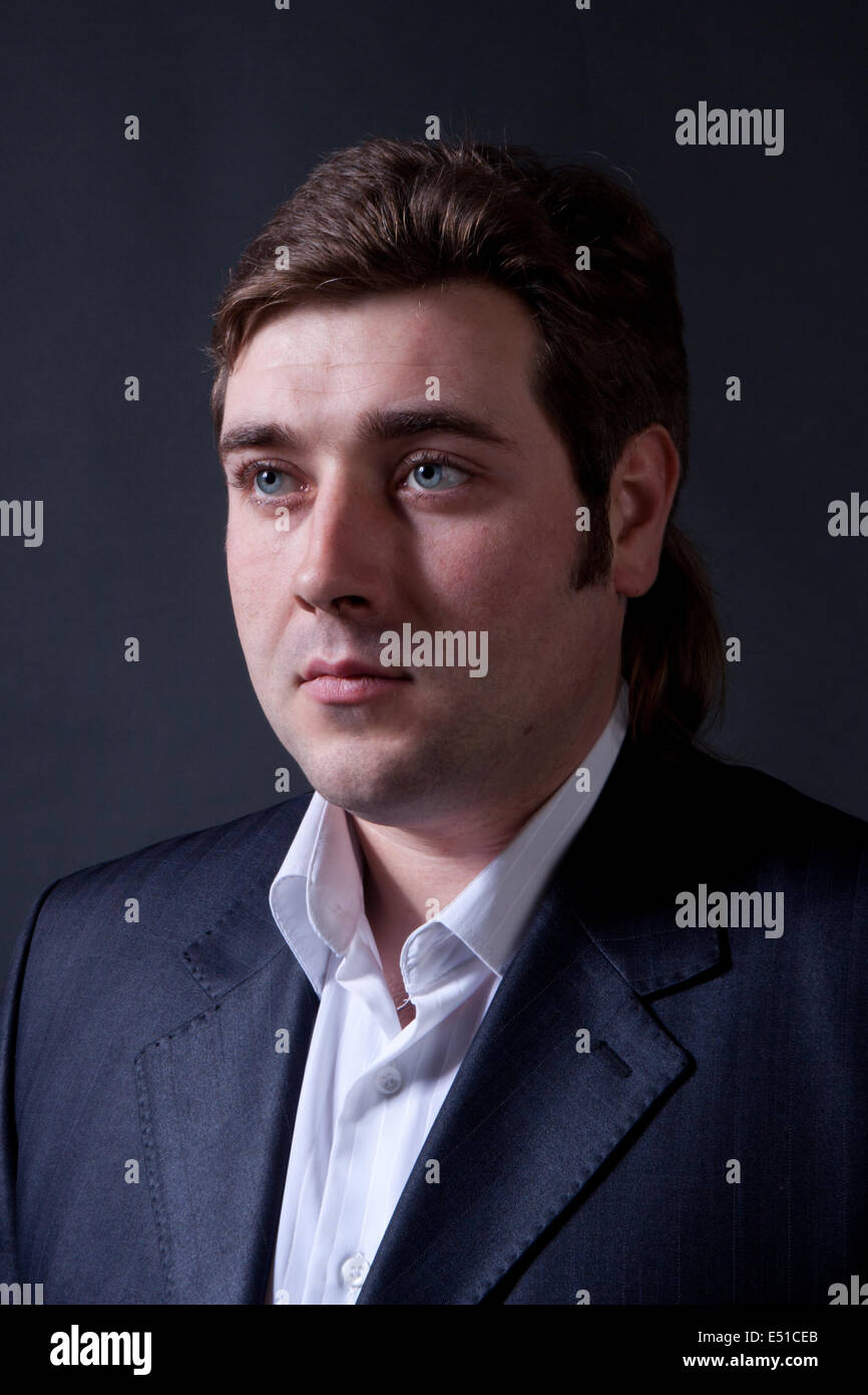 man in a black suit with a gray background Stock Photo - Alamy