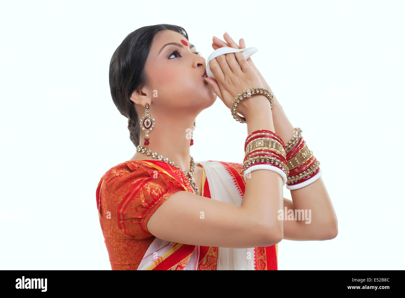 Bengali woman blowing on a conch shell Stock Photo