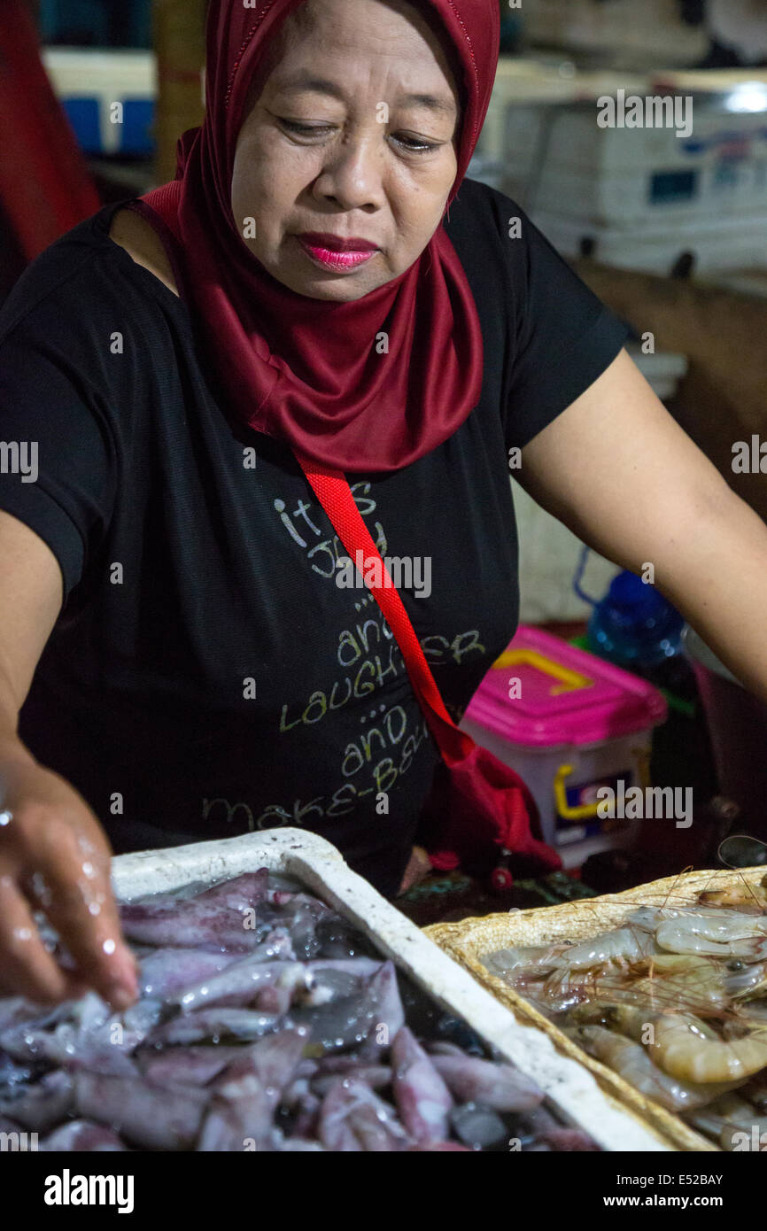 Bali, Indonesia.  Shrimp Vendor Arranges her Morning Offerings. Stock Photo