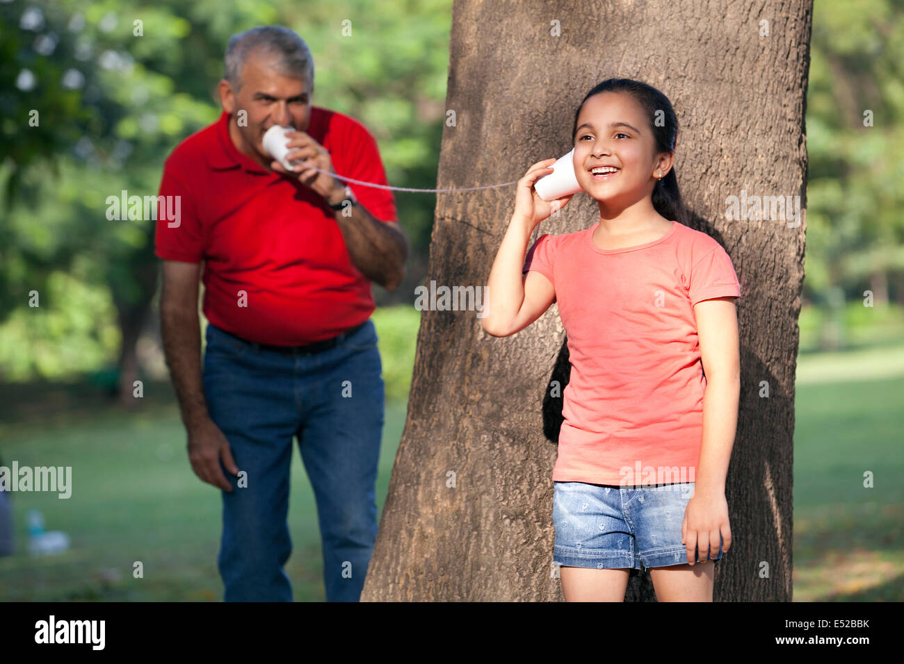 Girl listening man through cup hi-res stock photography and images - Alamy