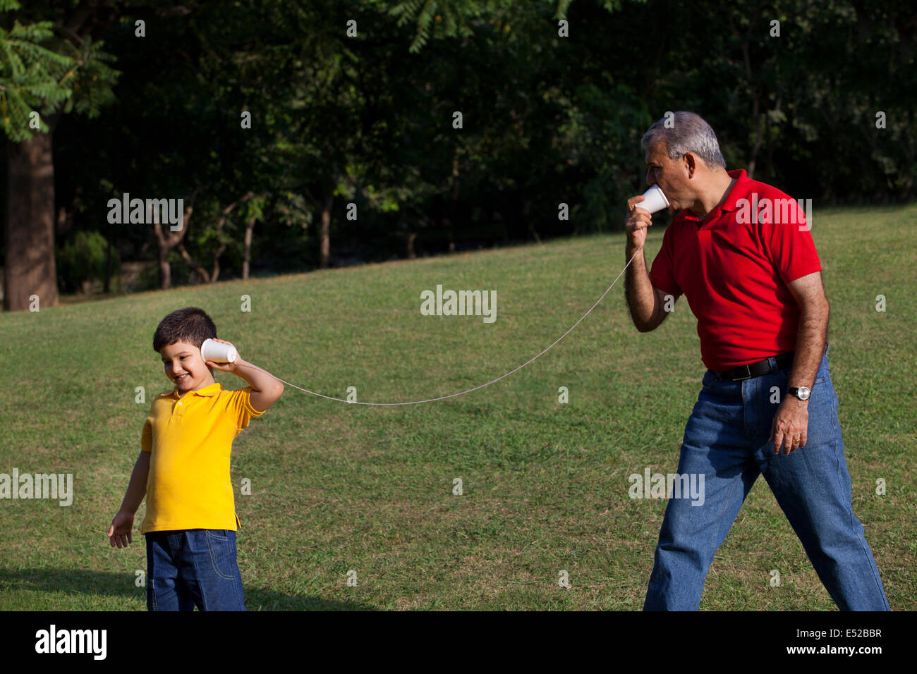Grandfather and grandson talking through paper cups Stock Photo - Alamy