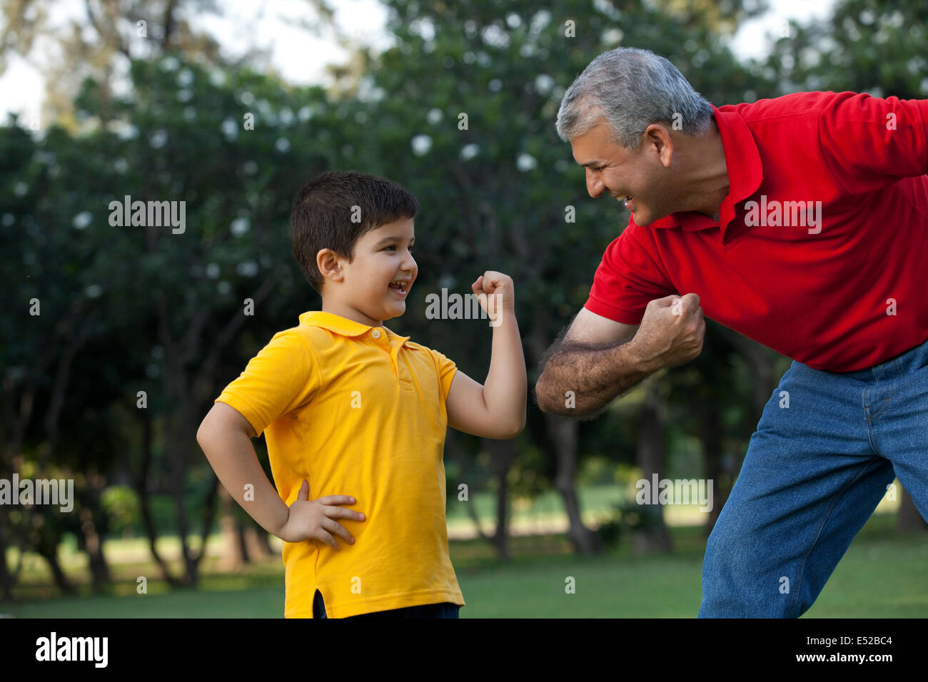 Grandfather and grandson flexing their muscles Stock Photo