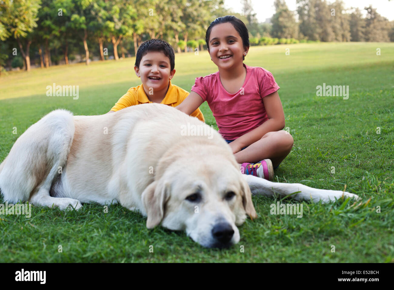Portrait of kids sitting with their dog Stock Photo