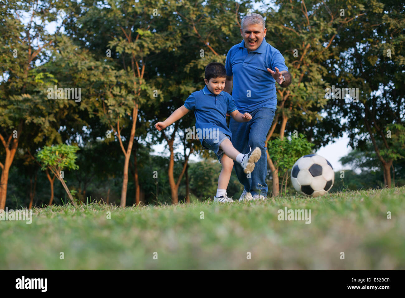 Grandfather and grandson playing soccer Stock Photo