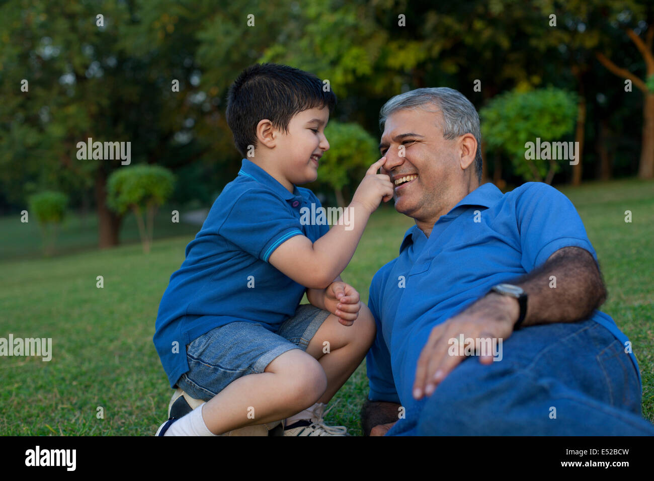 Grandson touching his grandfathers nose Stock Photo Alamy