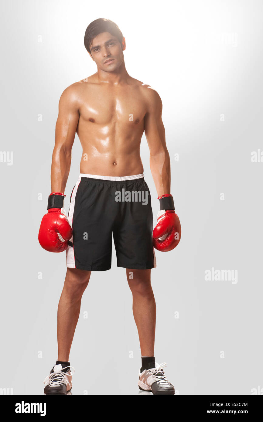 Full length portrait of shirtless boxer wearing boxing gloves against white  background Stock Photo - Alamy