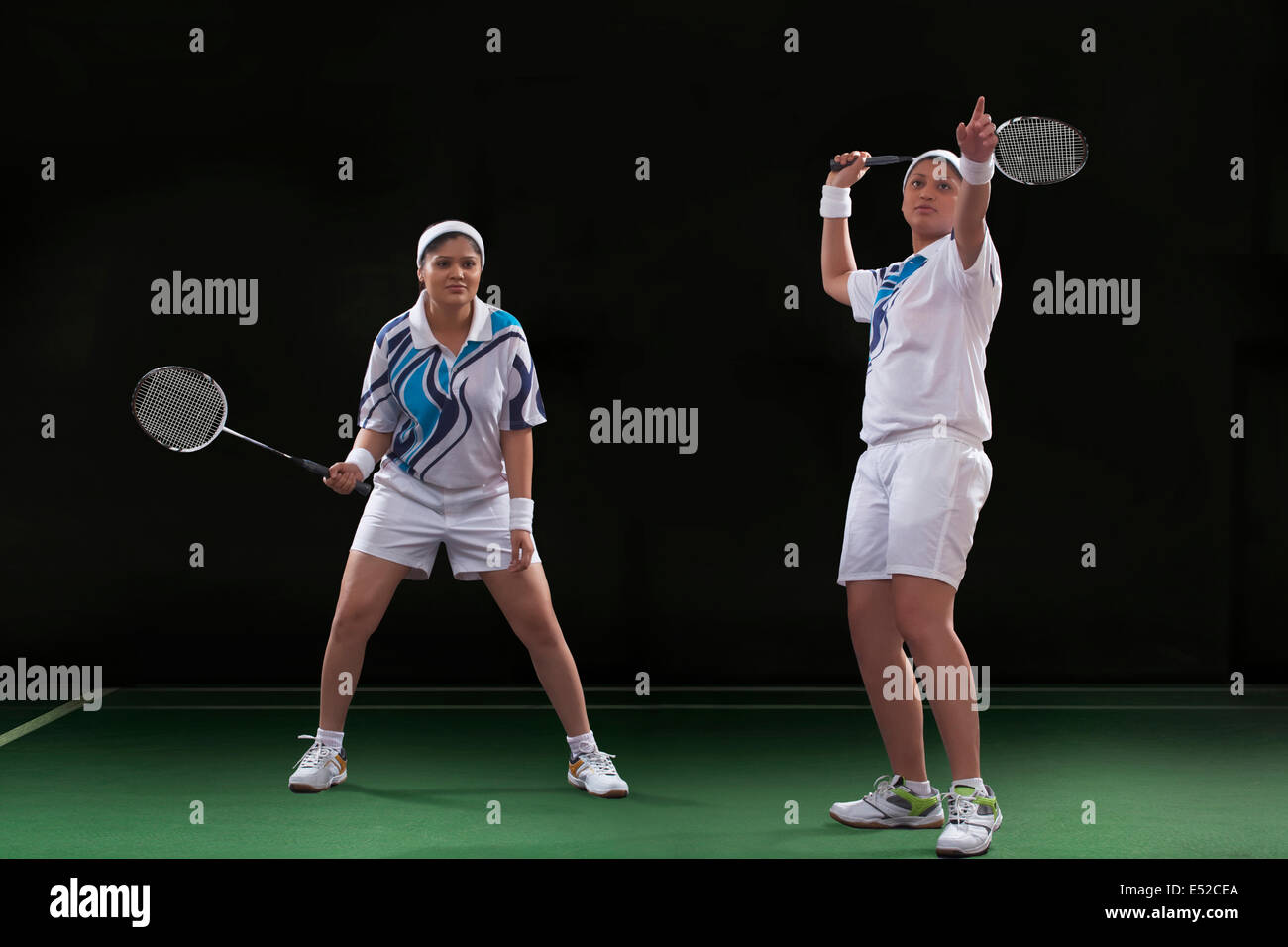 Young women playing badminton over black background Stock Photo