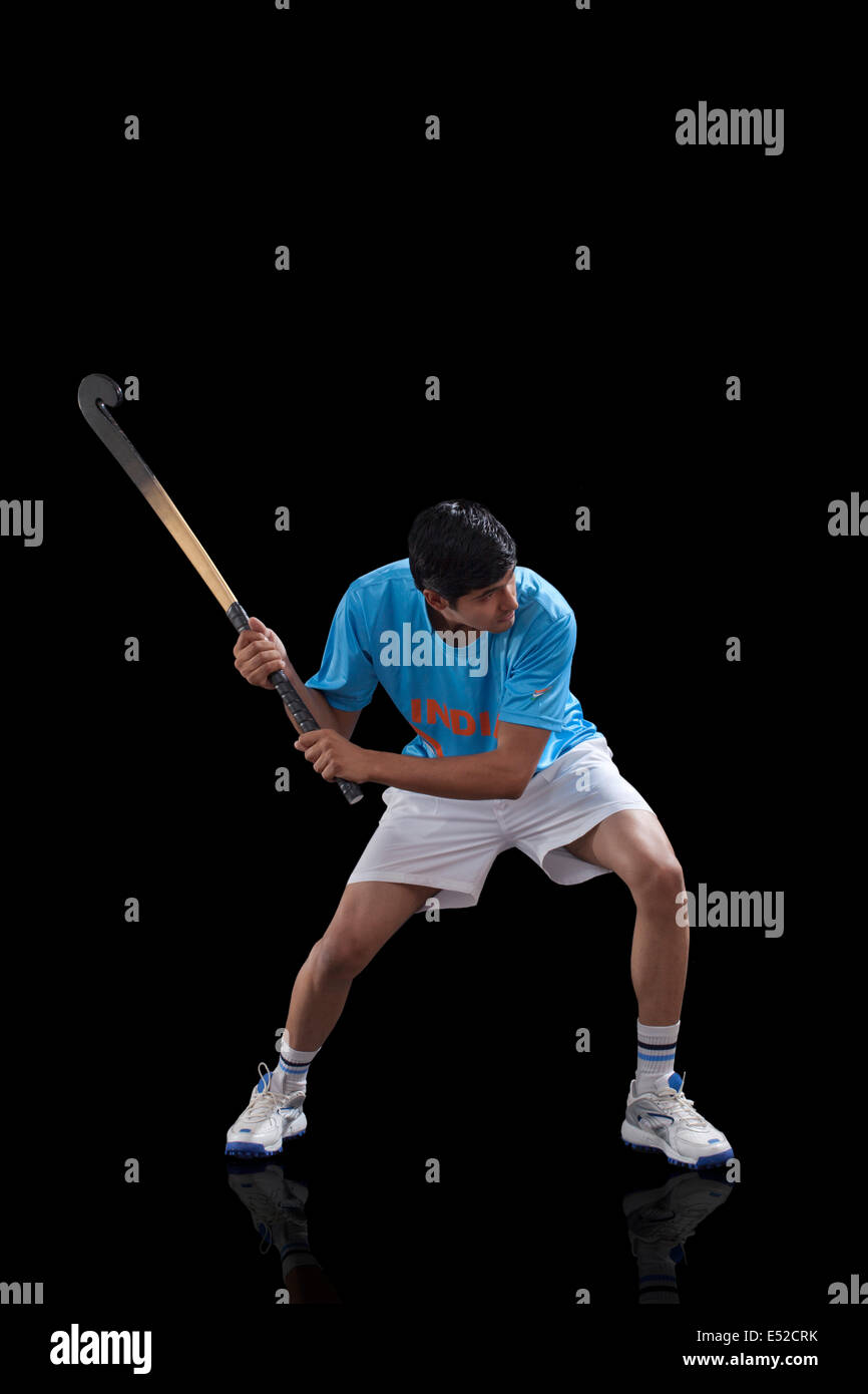 An Indian sportsman practicing hockey isolated over black background Stock Photo
