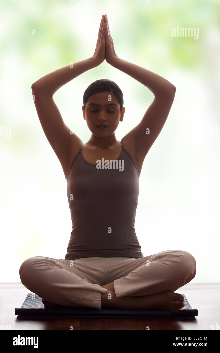 Young woman meditating on floor Stock Photo - Alamy