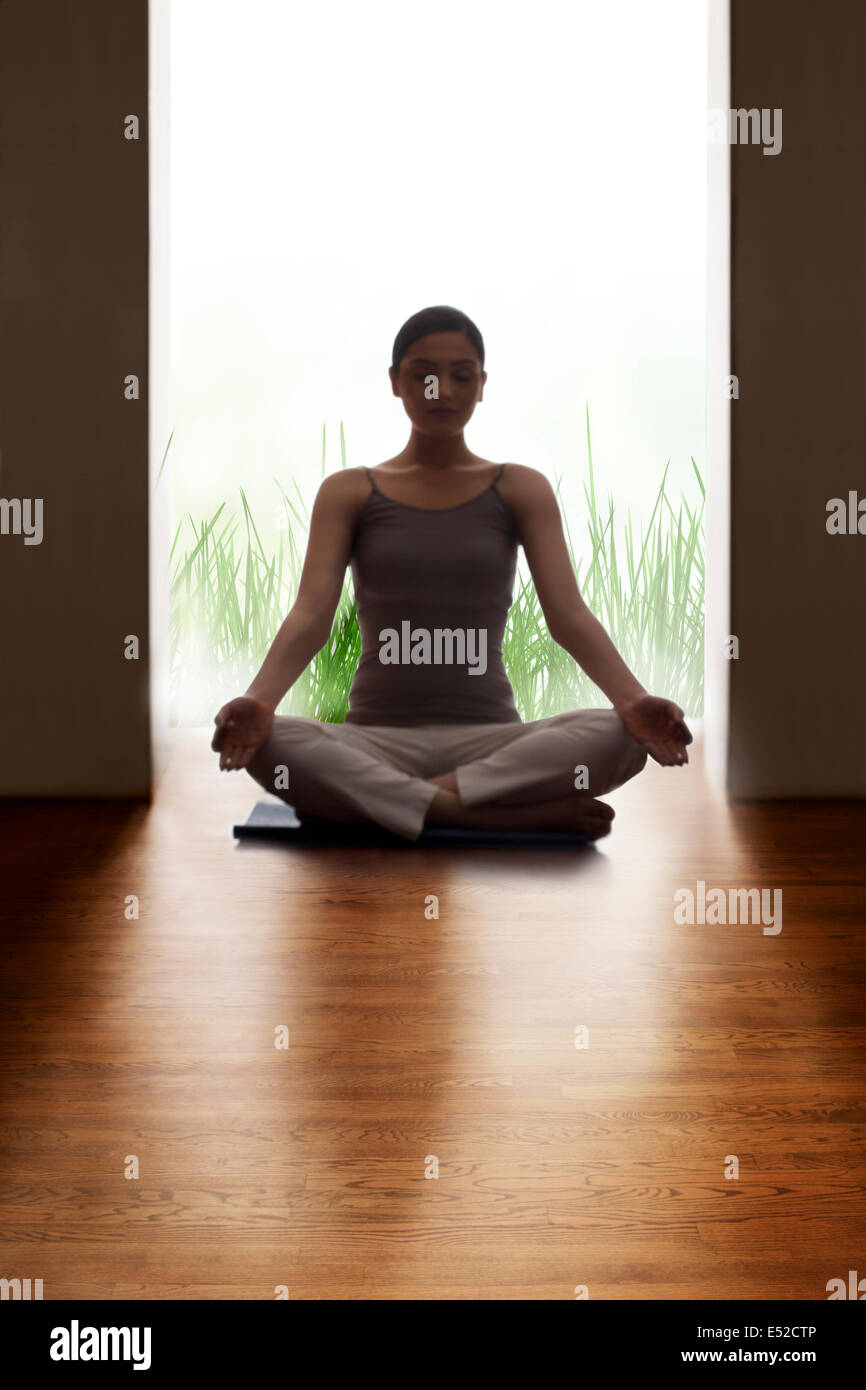 Young woman meditating on hardwood floor Stock Photo - Alamy