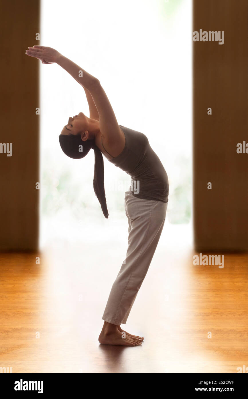 Profile Shot Of Young Woman Doing Back Bend Yoga Pose On Wooden