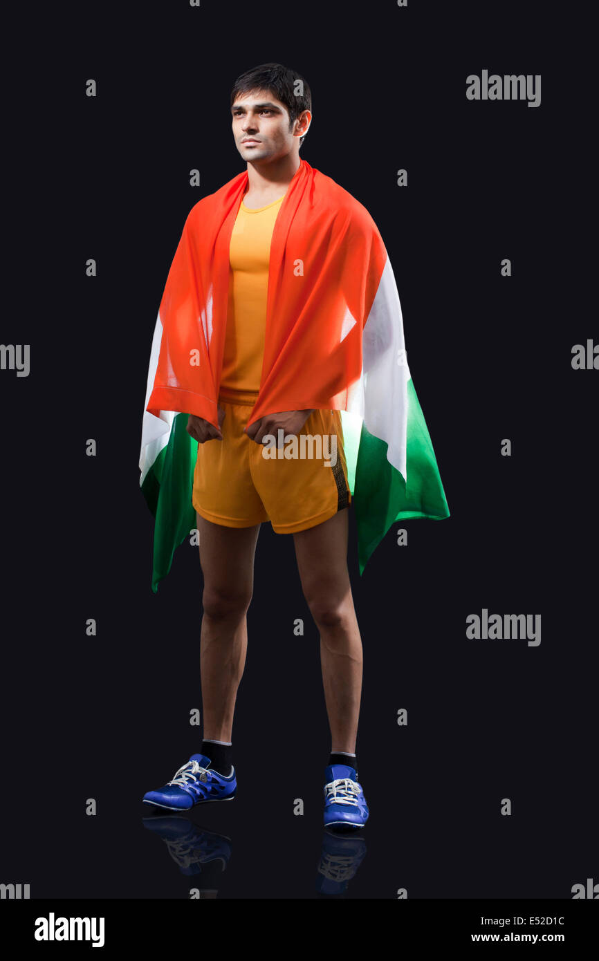 Young male runner with Indian flag standing against black background Stock Photo