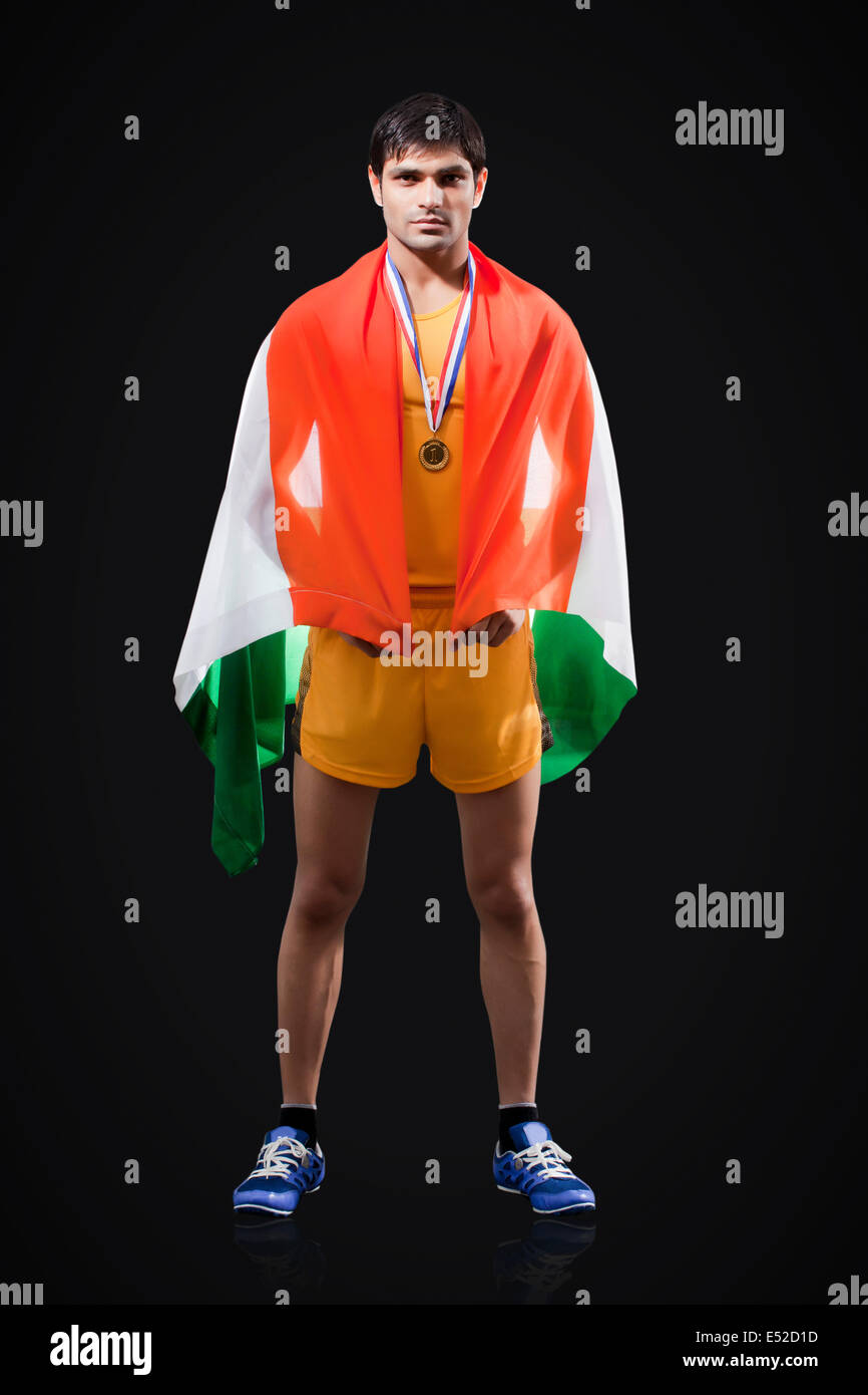 Full length portrait of male medalist with Indian flag standing against black background Stock Photo