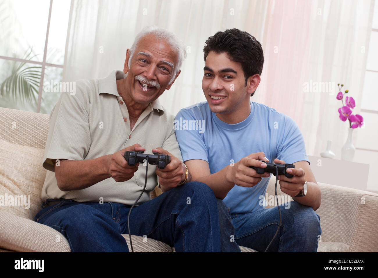 Grandfather and grandson playing video game Stock Photo