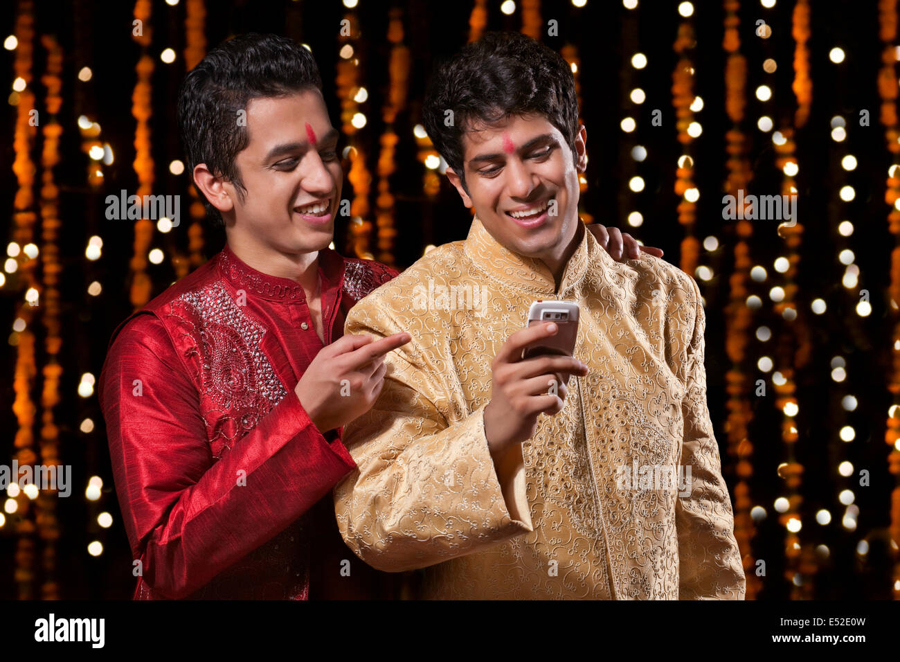 Men smiling at sms on mobile phone Stock Photo