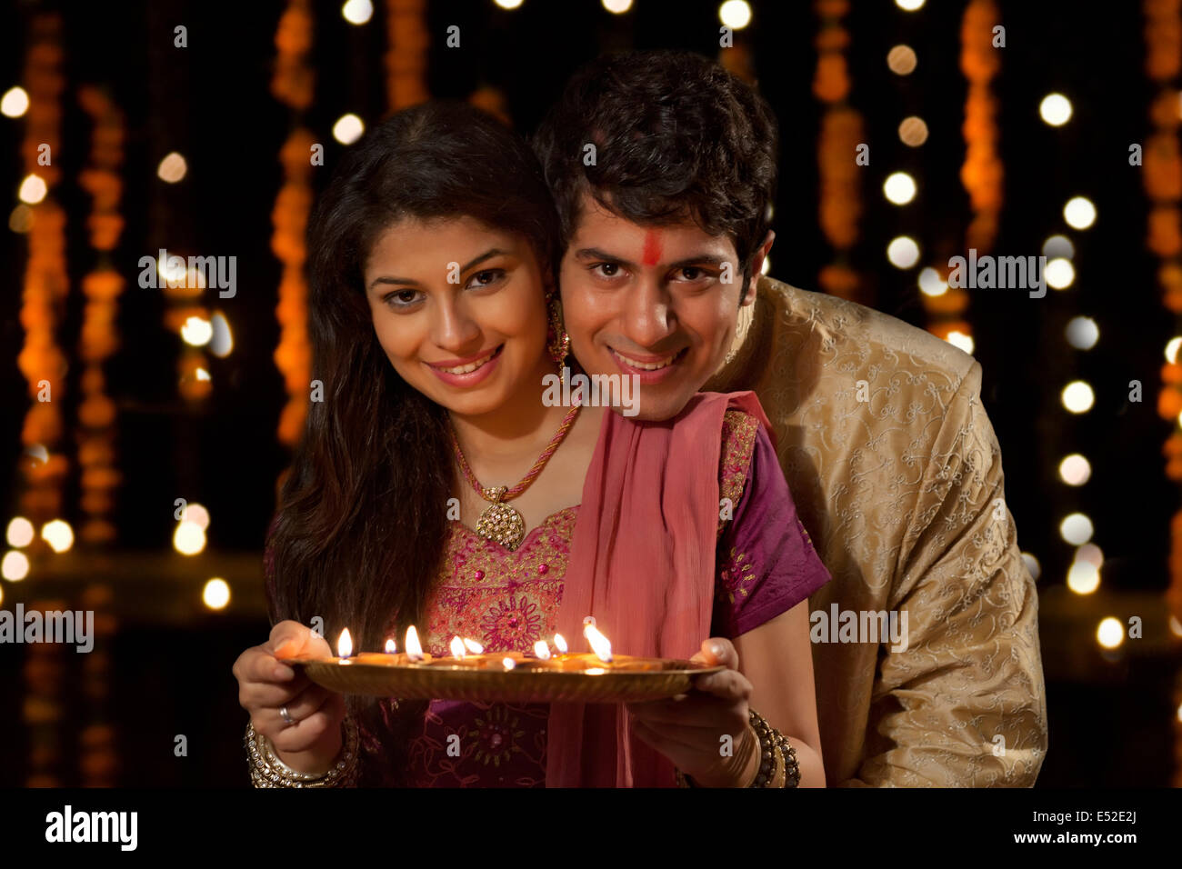 Image of Indian couple celebrating Diwali festival / anniversary or  birthday with gifts and sweets-OL224593-Picxy