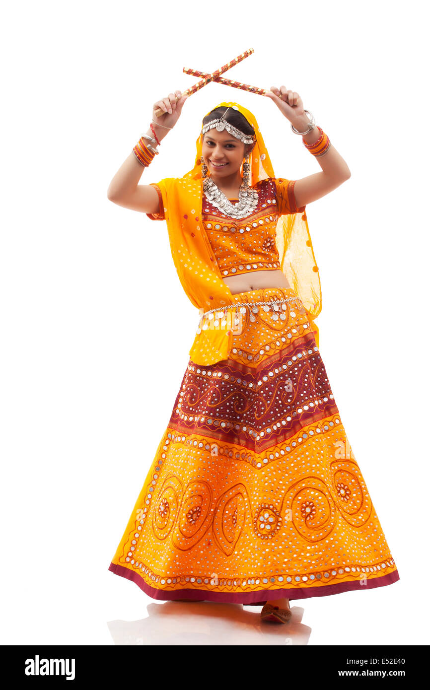Full length portrait of happy young woman playing Dandiya Raas isolated ...