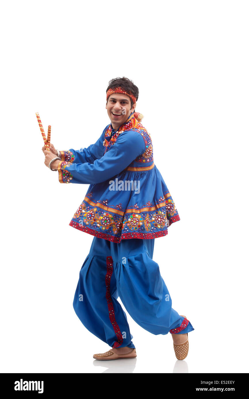 Portrait of happy man in kedia and dhoti performing Dandiya Rass ...