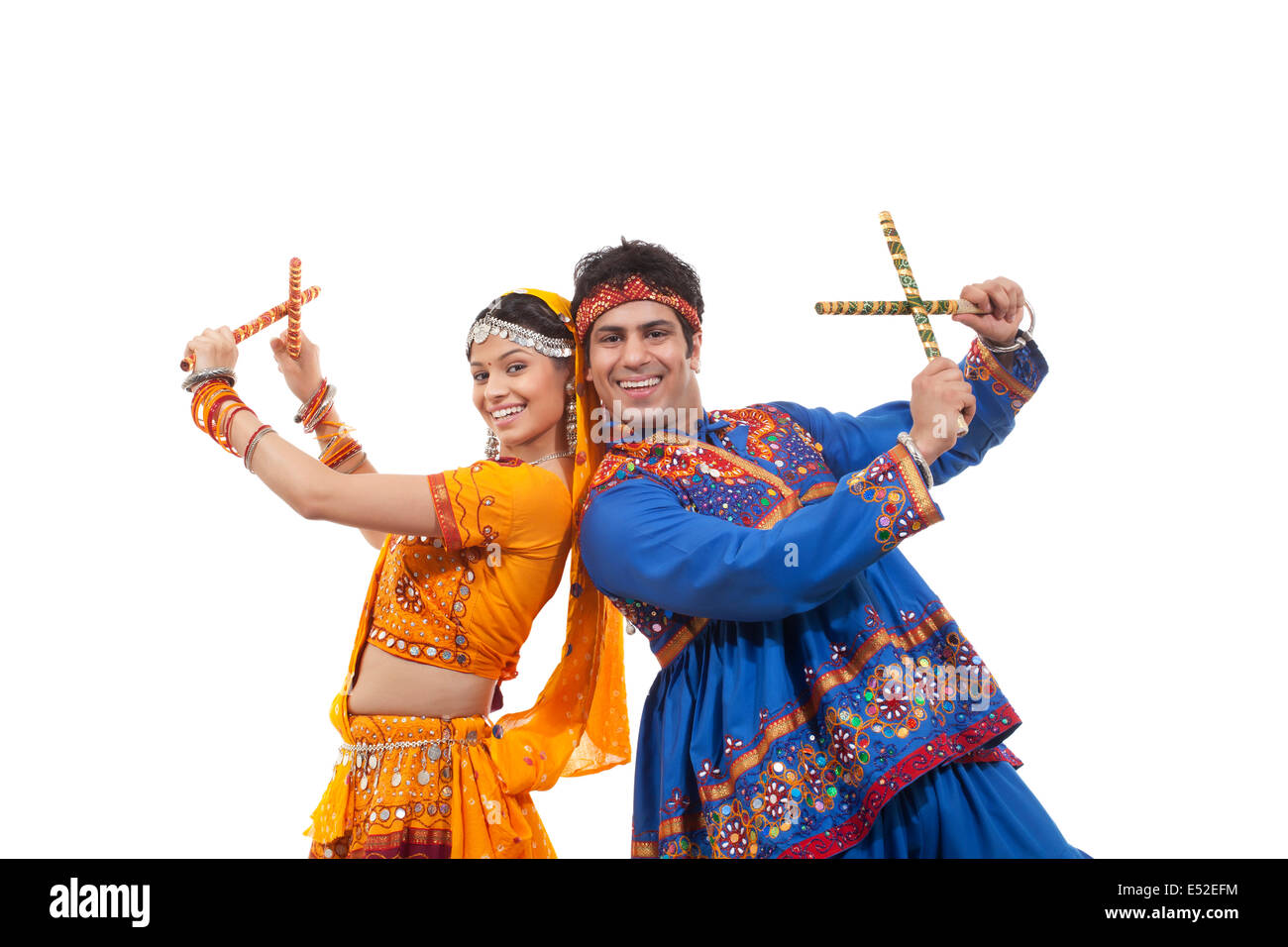 Portrait of happy young couple in traditional wear standing back to ...