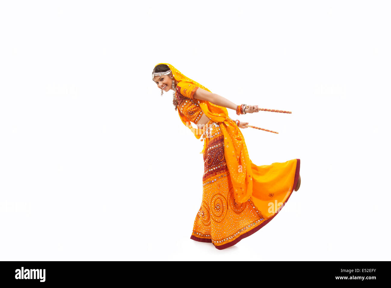 Full length portrait of young woman in chaniya choli performing Dandiya ...