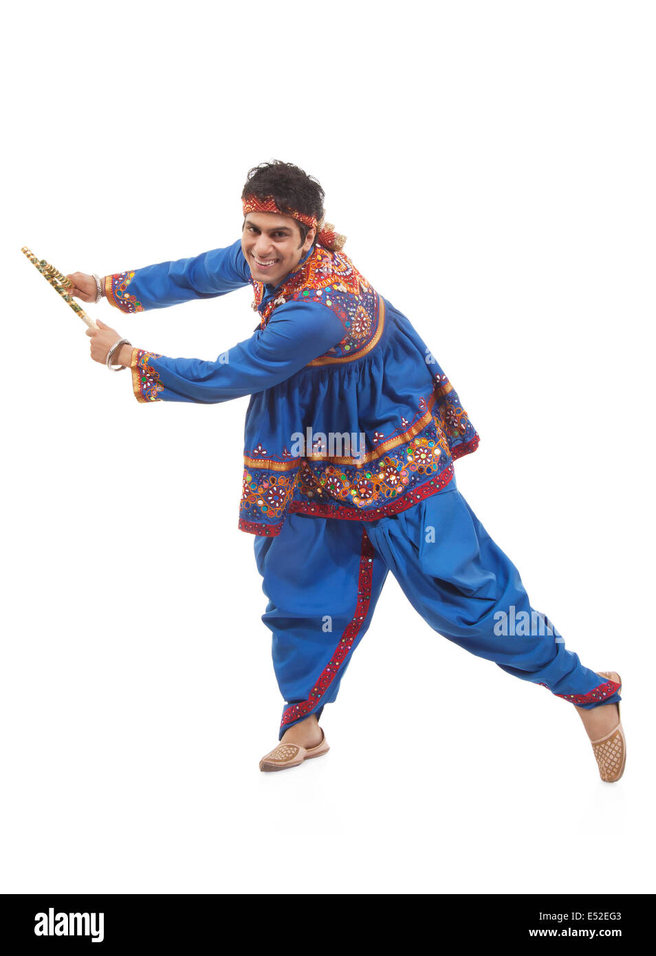 Portrait of an Indian man performing Dandiya Raas over white background ...
