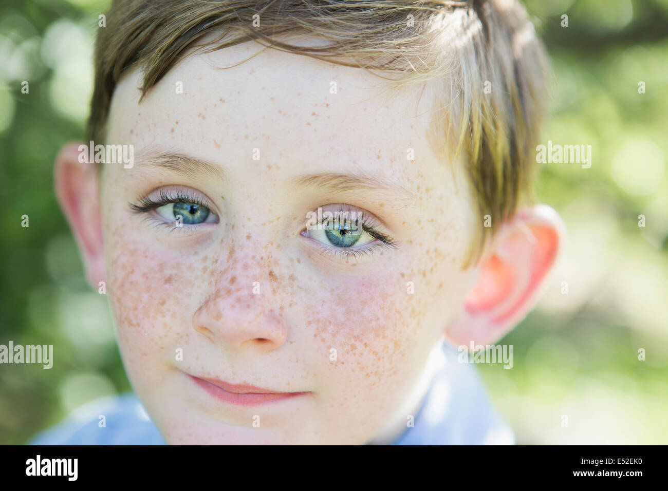 Portrait of a young boy with red hair, blue eyes and freckles on his nose. Stock Photo