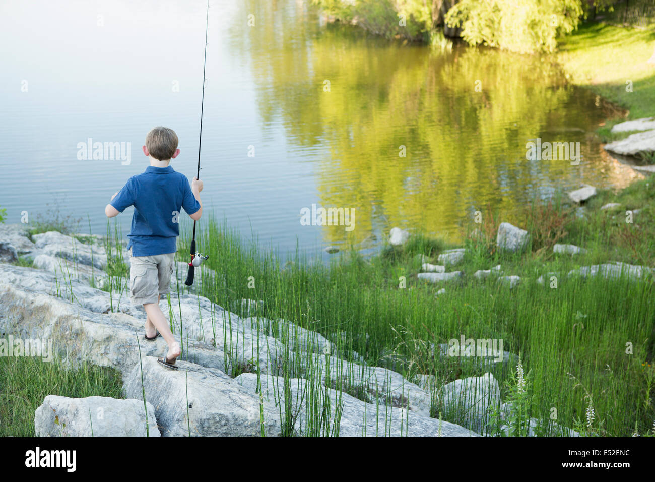 Boy fishing on riverbank hi-res stock photography and images - Alamy