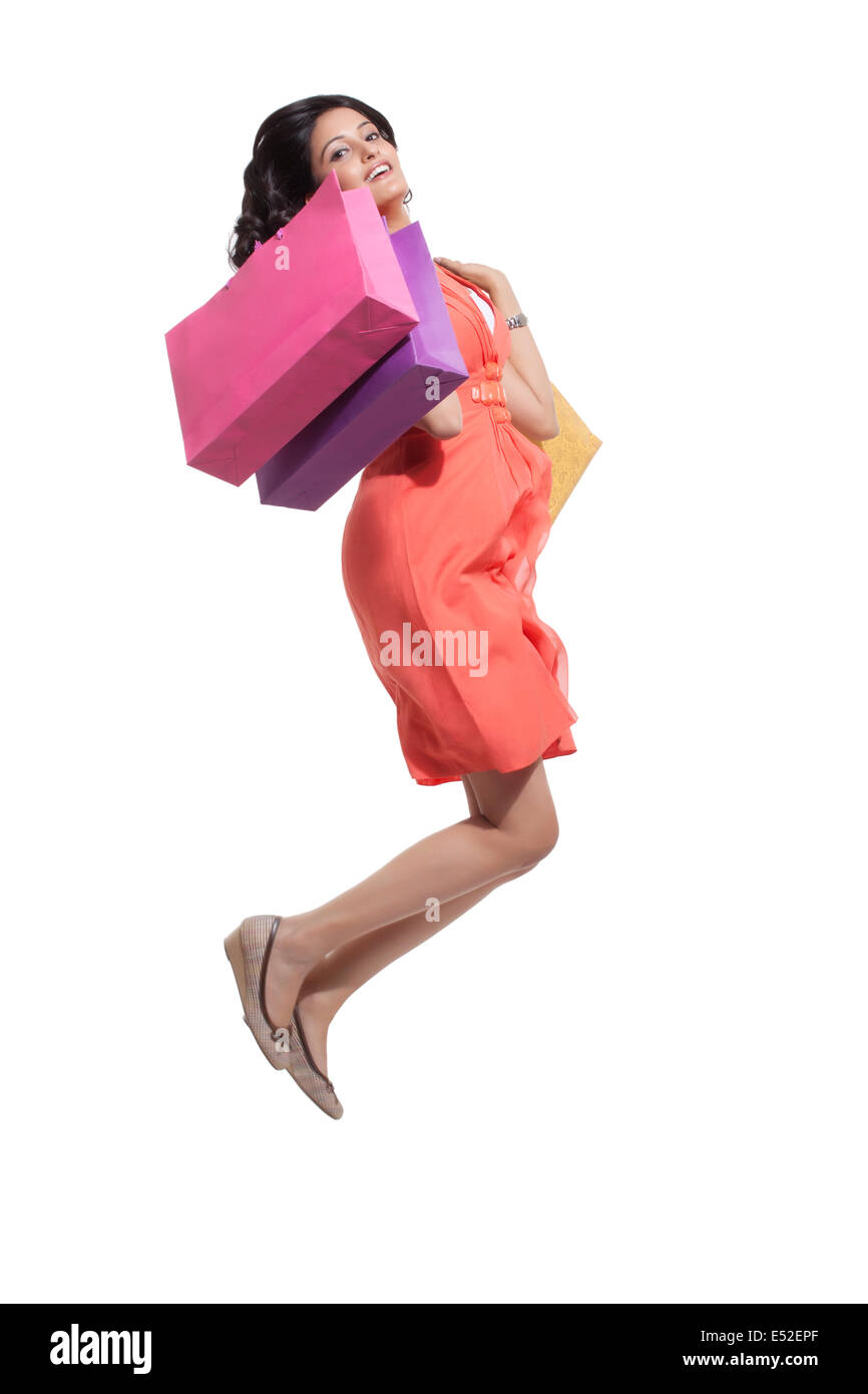 Portrait of a woman jumping with shopping bags Stock Photo